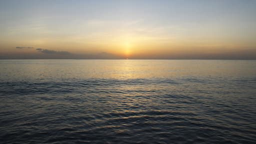 Calming and beautiful orange sunset against blue seashore