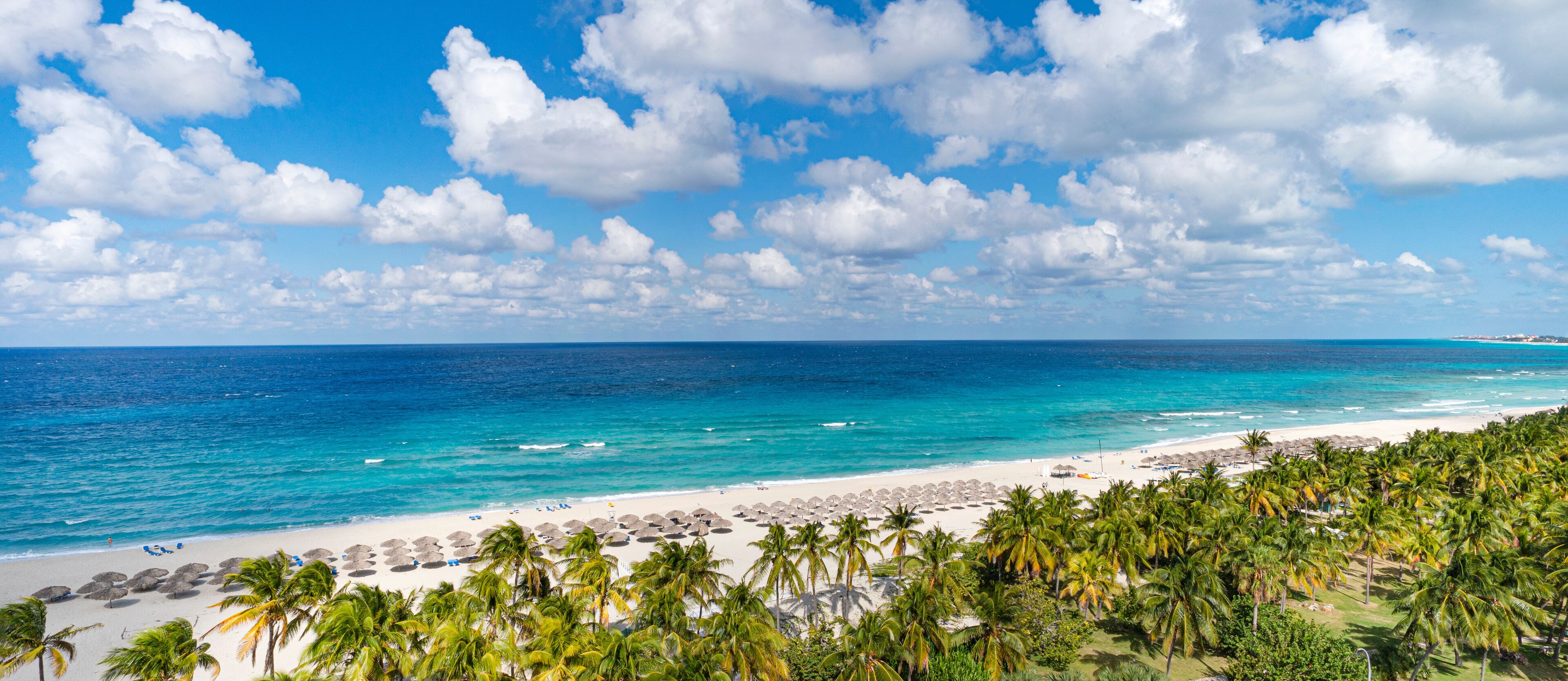 Top view of the Caribbean dream beach in Varadero Cuba with sun lounger and thatched huts. Panoramic view of 20 km long beach of the resort town of Varadero.
