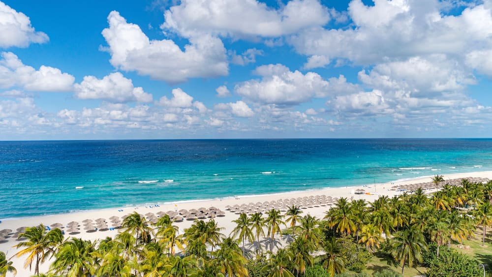 Top view of the Caribbean dream beach in Varadero Cuba with sun lounger and thatched huts. Panoramic view of 20 km long beach of the resort town of Varadero.
