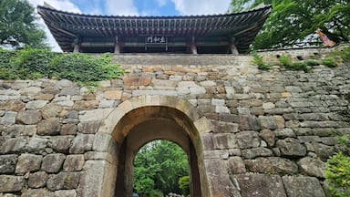 Um portão coreano tradicional com paredes de pedra e telhado telhado.