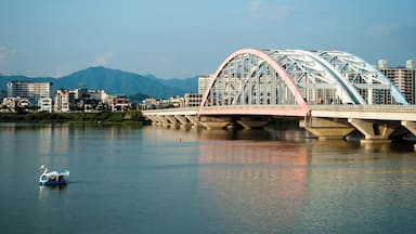 A bridge over a river with a swan boat in the foreground.