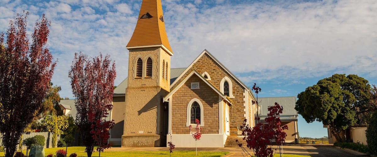 A church with a tall steeple and a brick facade.