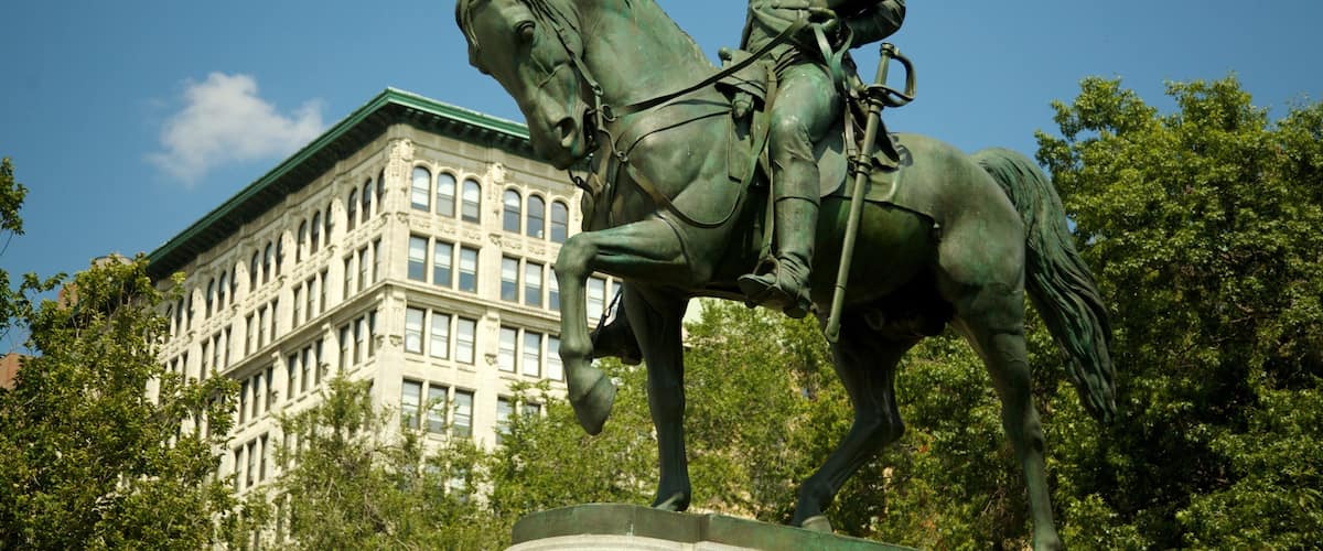 Union Square Park in New York City features a statue of George Washington on horseback among lush trees and vibrant outdoor activity