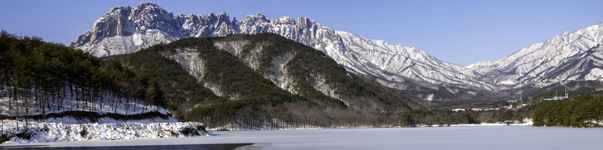 Winter and morning view of water and melting ice on Wonam Reservoir against snow covered Ulsanbawi Rock at Wonam-ri of Gosung-gun, Gangwon-do, South Korea