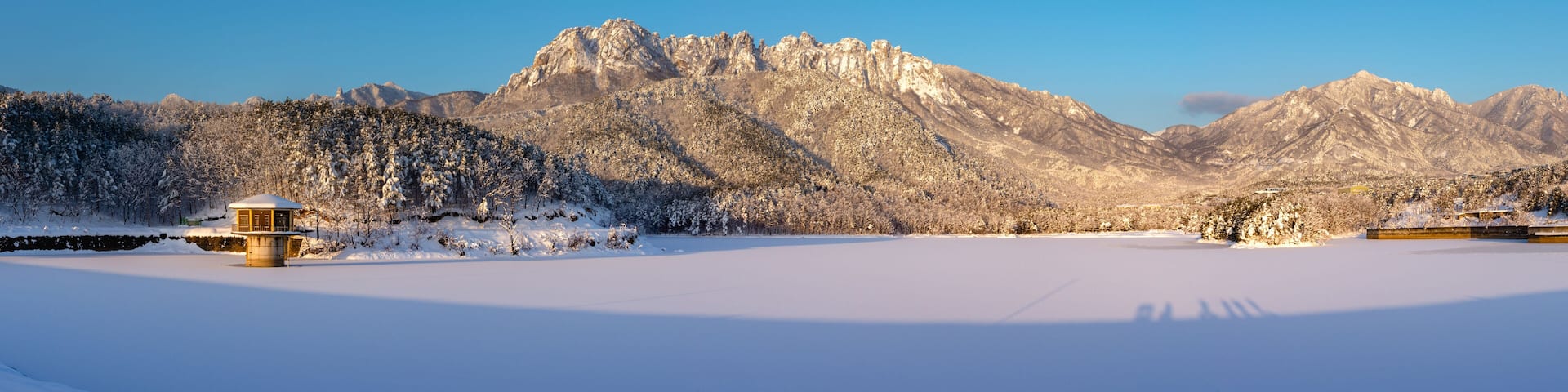 Panoramic and morning view of snow covered Wonam Reservoir with the background of Ulsanrock of Seoraksan Mountain near Goseong-gun, South Korea