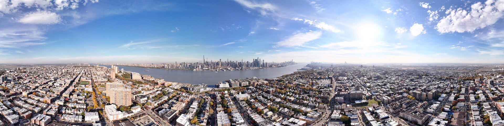 Vista panorâmica de uma cidade com rio, área urbana densa e horizonte distante.
