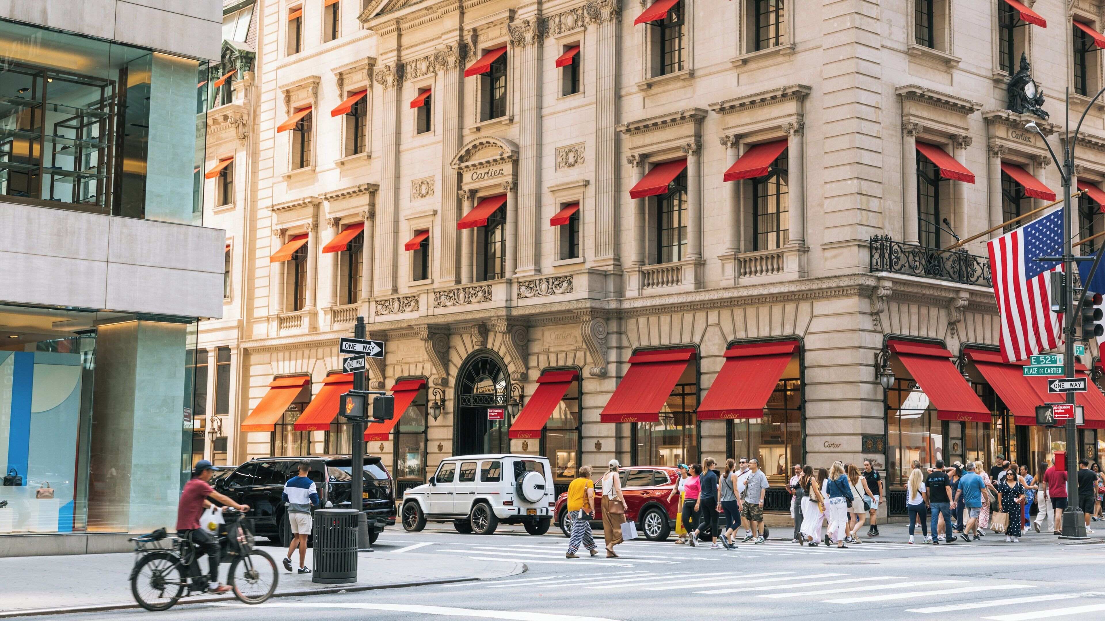 Busy day on 5th Avenue with pedestrians and cyclists enjoying the lively Manhattan atmosphere in New York City