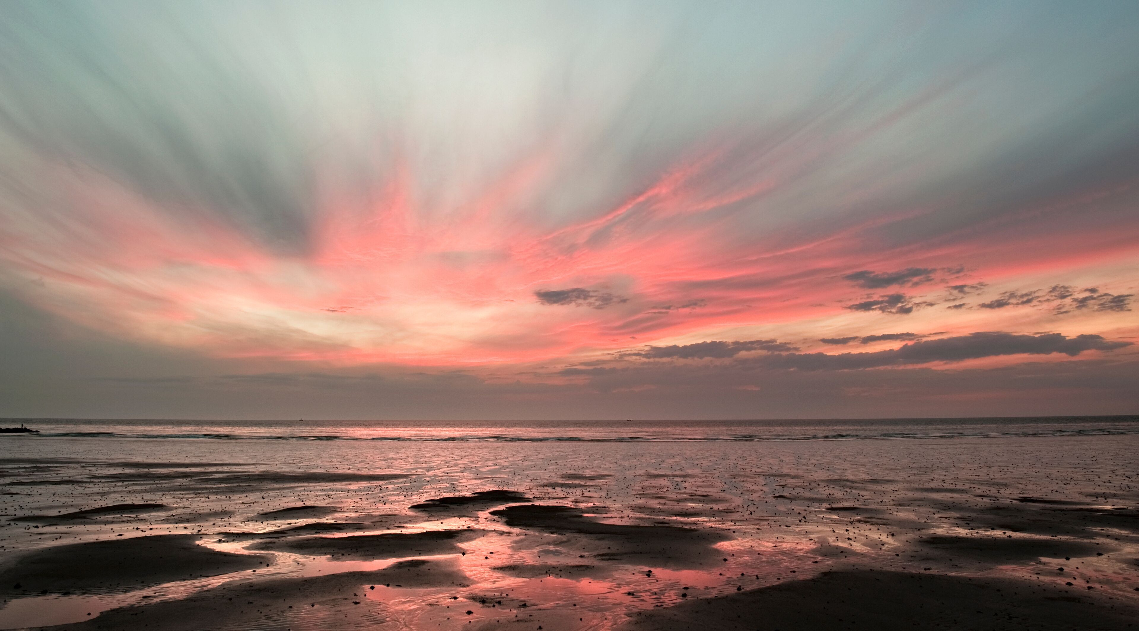 Sunset with pink clouds over Wenduine beach at low tide