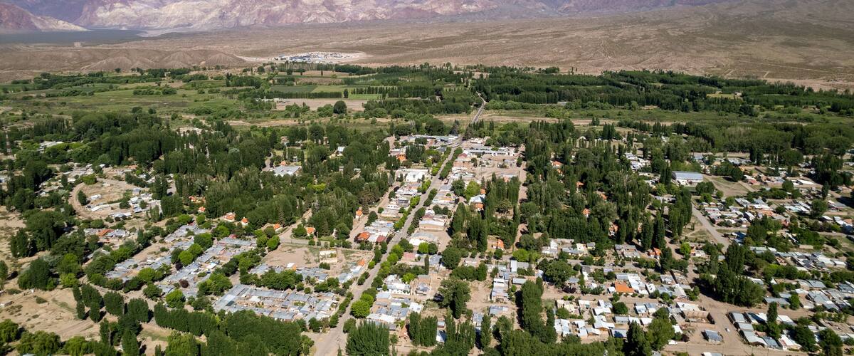 A town nestled in a valley with a backdrop of snow-capped mountains.