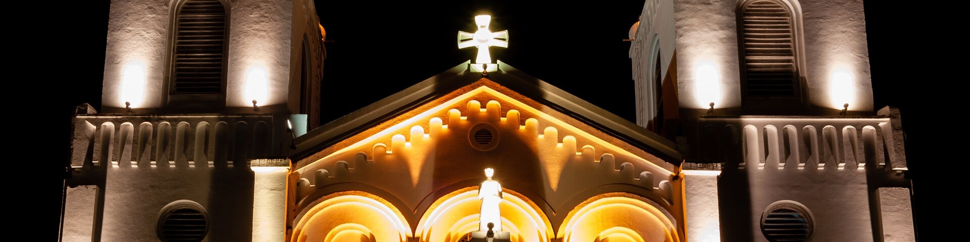 Una iglesia con dos torres, cada una coronada por una cruz, y una cúpula central también con cruz.