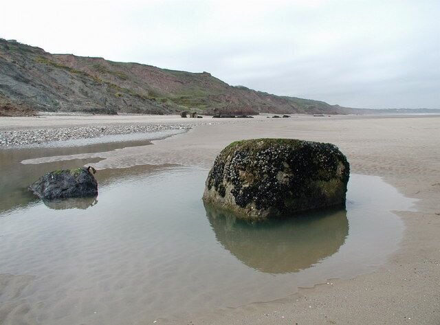 Middle Cliff Beach, Speeton Sands Heavily eroded anti-tank blocks on the beach north of Speeton, looking west-northwest towards New Closes Cliff and Reighton Gap.