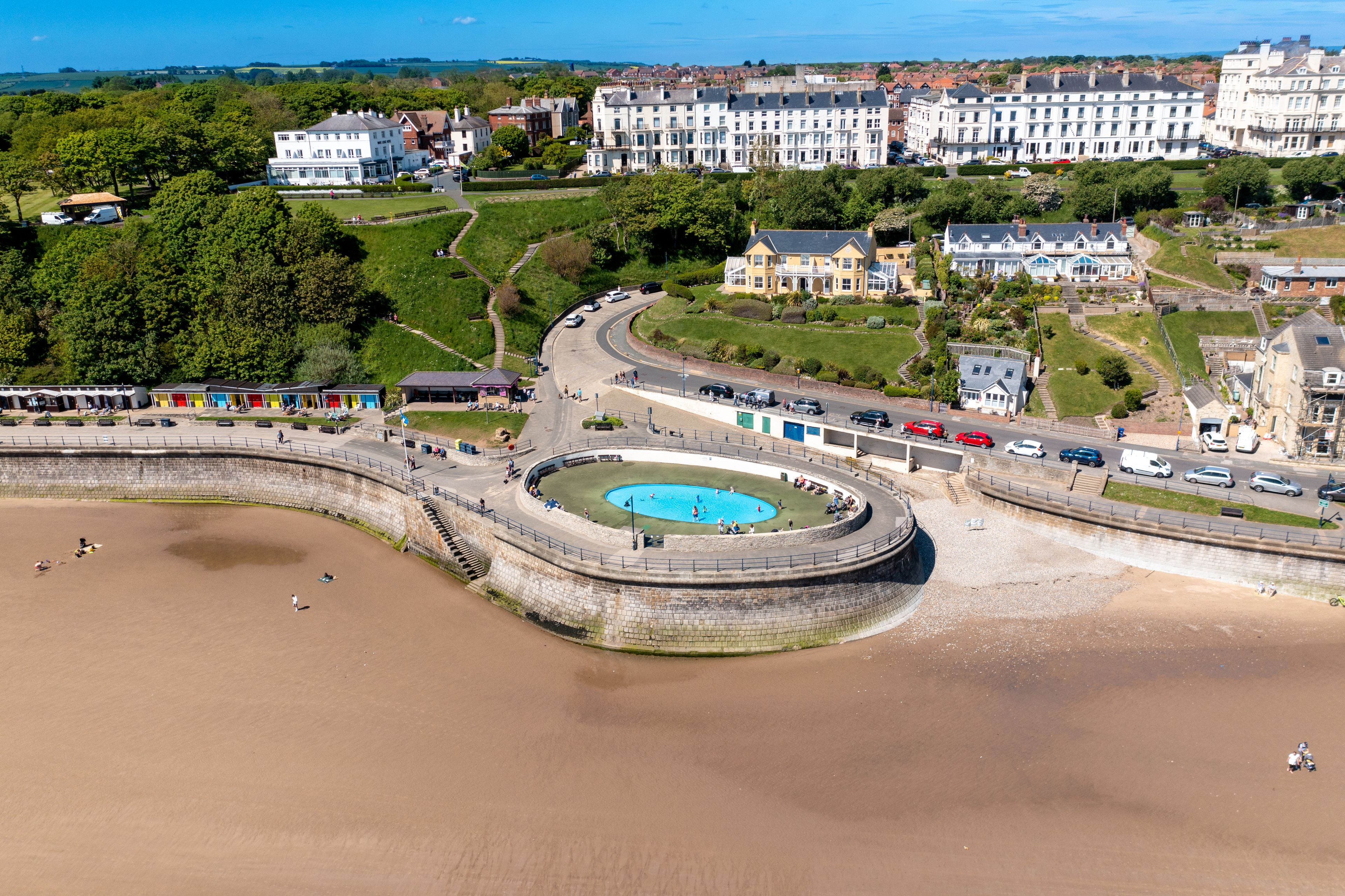 Aerial photo of the beautiful town of Filey in the UK, showing the beach front and open air public swimming pool on a sunny summers day
