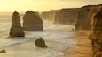 Twelve Apostles showing rocky coastline, a gorge or canyon and a sunset