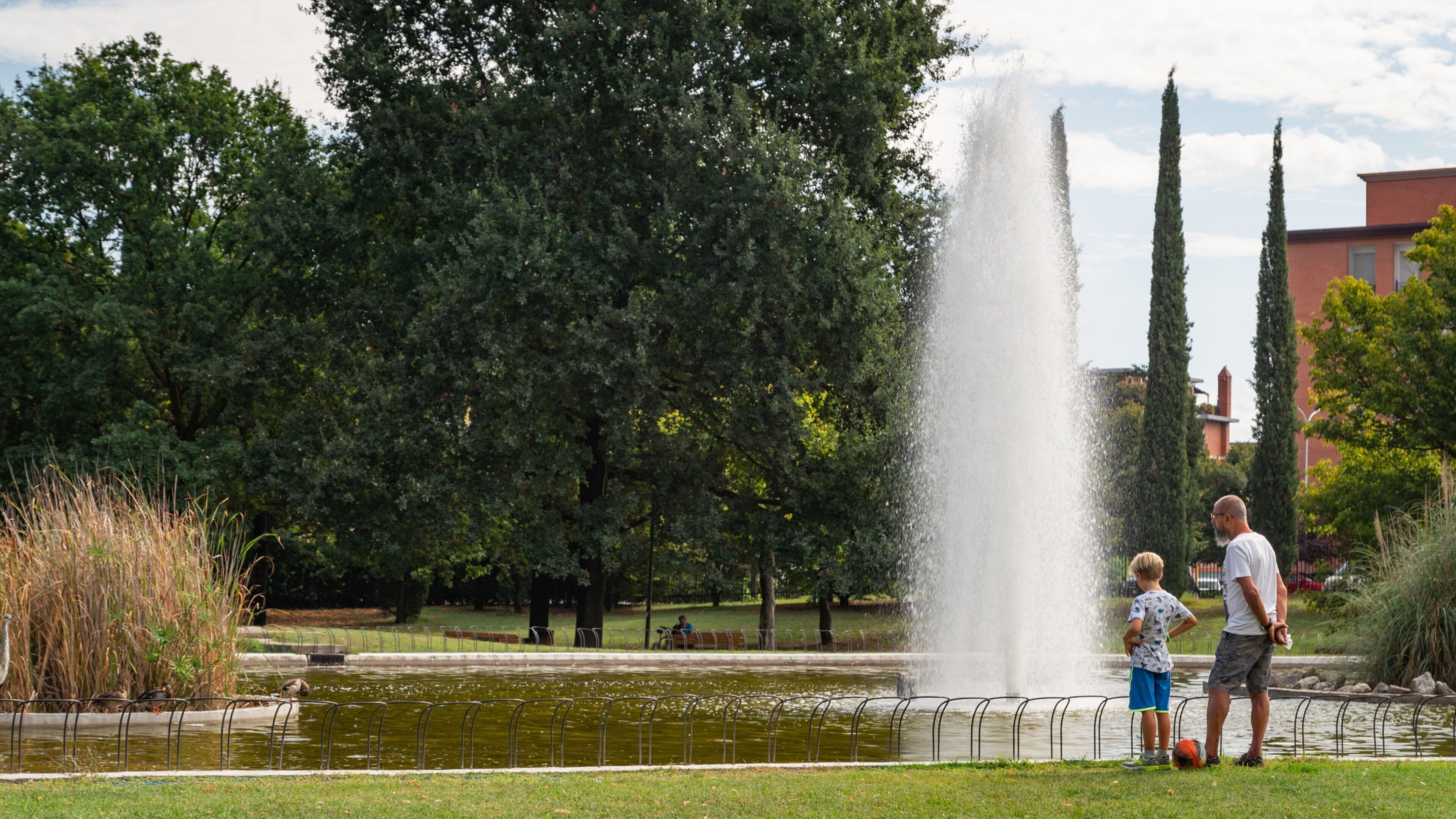 Isolotto showing a fountain and a pond as well as a family