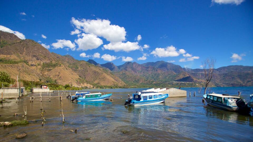 A lake with boats, mountains, and a clear sky.