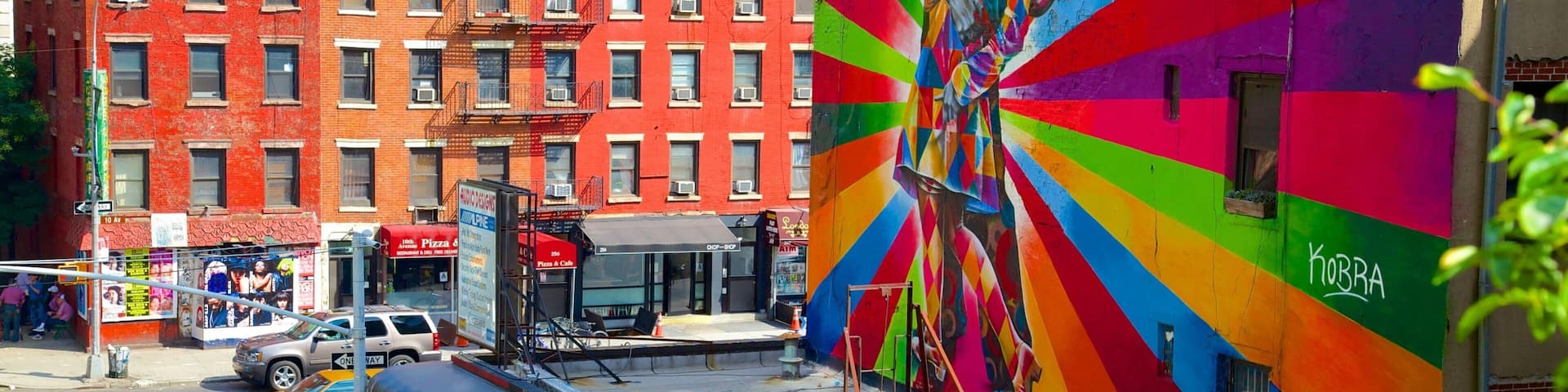 A vibrant street mural with a rainbow pattern and the word "KOBRA" on a building.