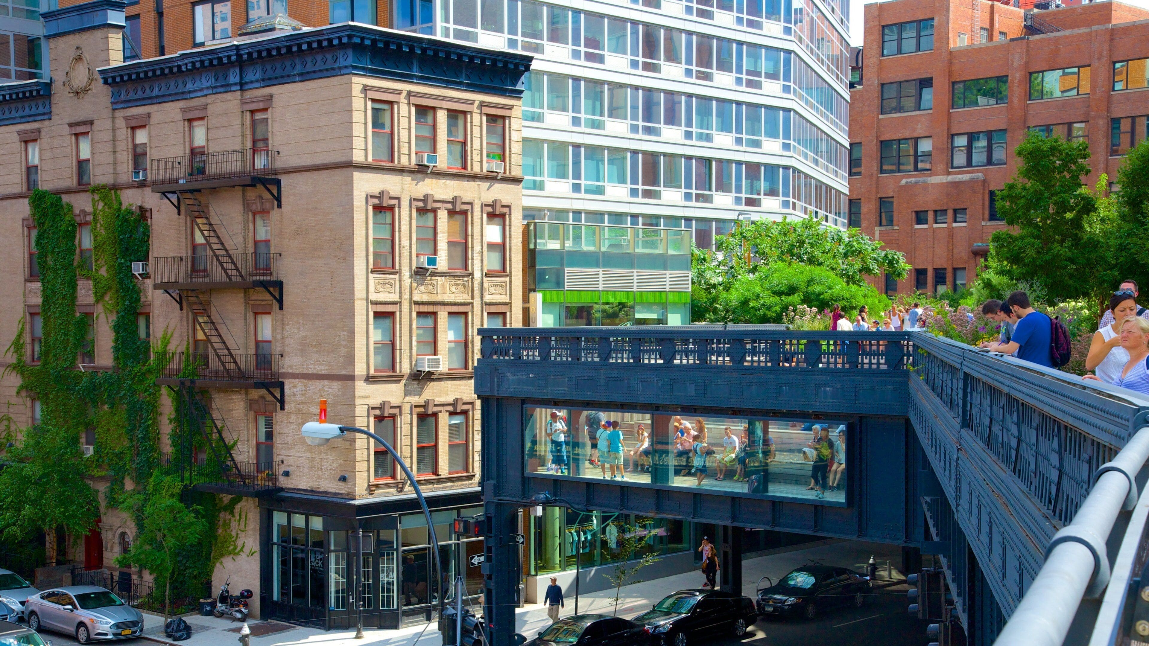 A city street with a pedestrian bridge, buildings, and cars.