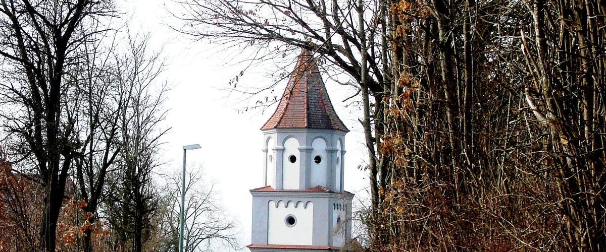 A narrow road leading to a white church with a red roof and a bell tower.