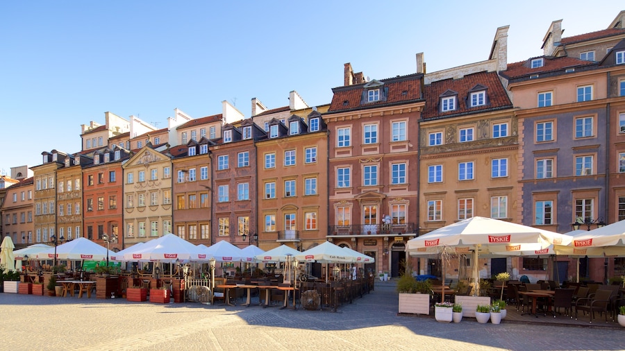 Eine Reihe bunter, historischer Gebäude mit Straßencafés und Tischen.
