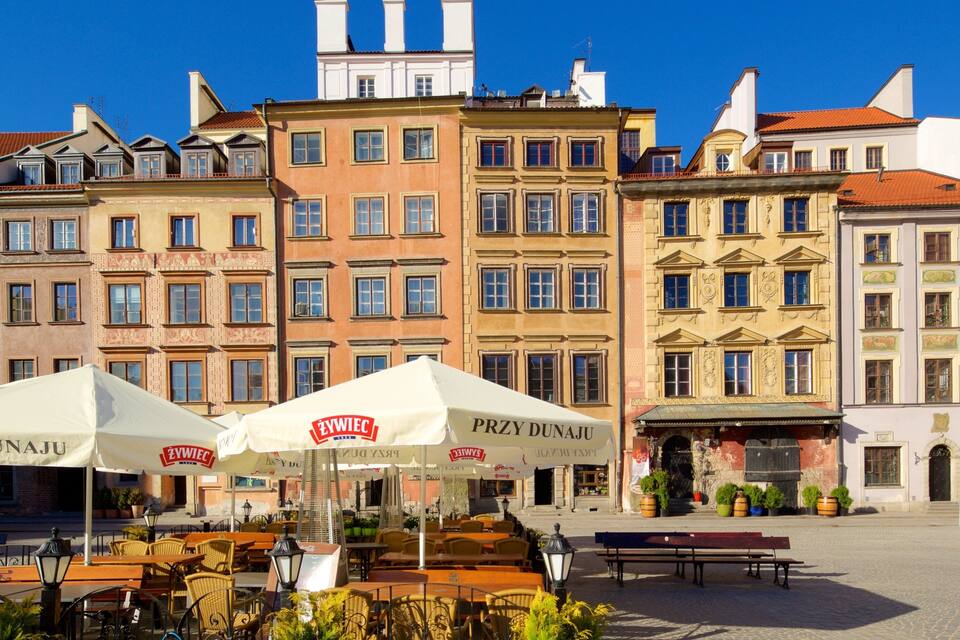 A European square with colorful buildings, outdoor cafes, and a cobblestone street.