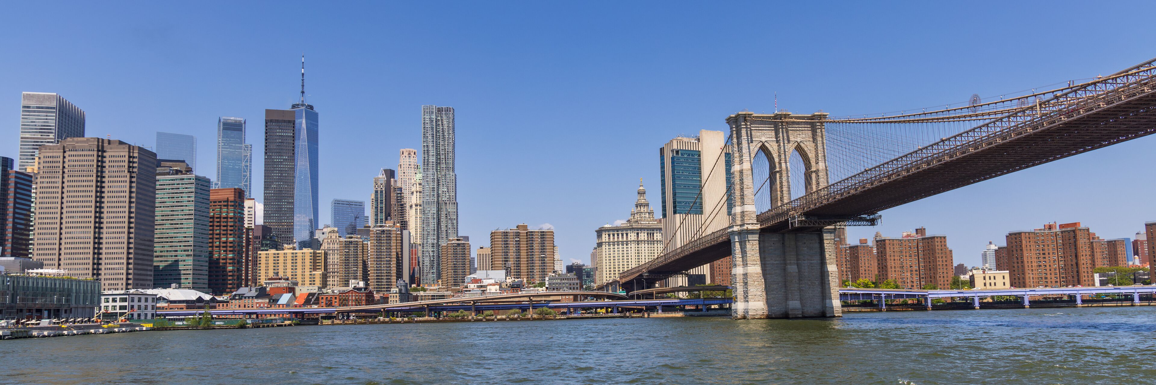 A city skyline with a prominent bridge spanning a river.