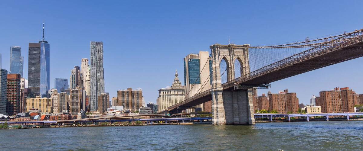 A city skyline with a prominent bridge spanning a river.