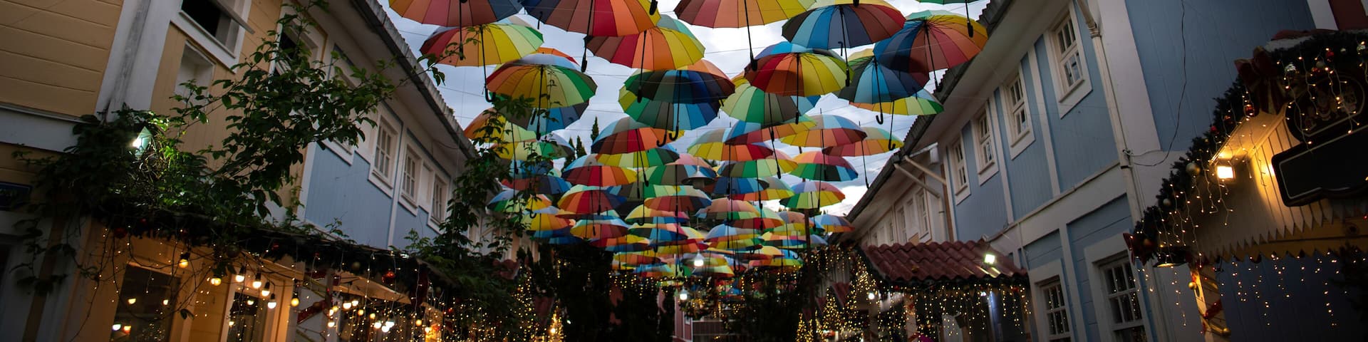 A street with colorful umbrellas hanging overhead.