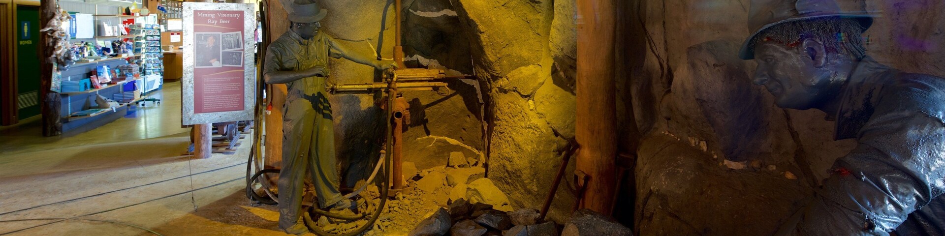 Una exposición minera con un casco de minero, herramientas y una muestra de rocas.
