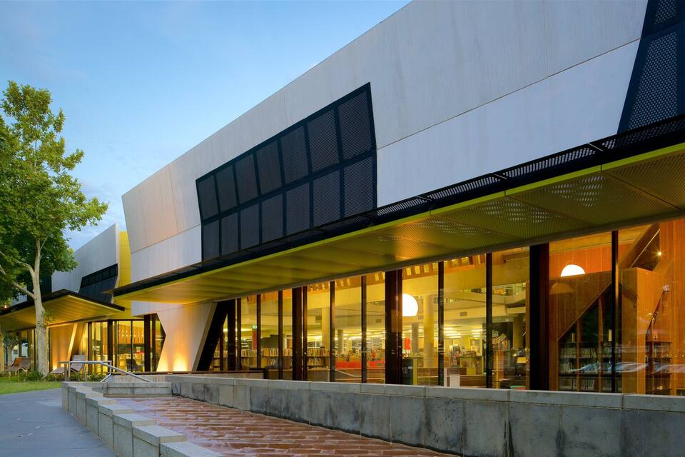 A modern building with large windows and a covered walkway.