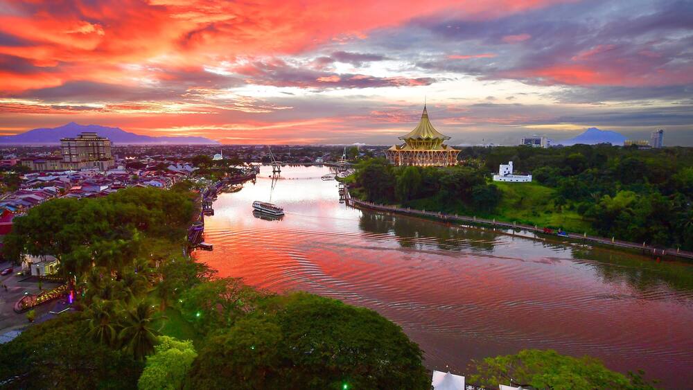 Kuching which includes a river or creek, a sunset and landscape views