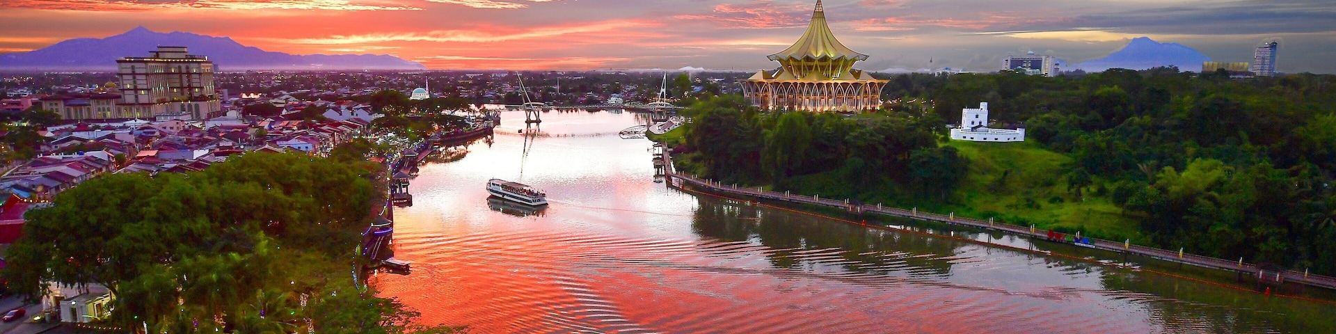 Kuching which includes a river or creek, a sunset and landscape views