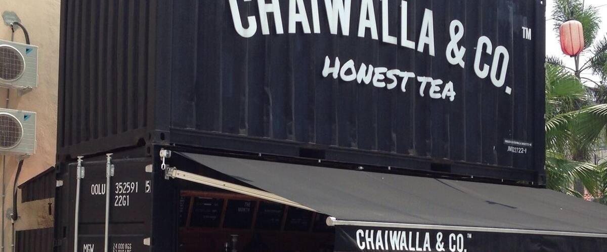A chaiwala & co. tea shop with a black facade and a sign that reads "Honest Tea".