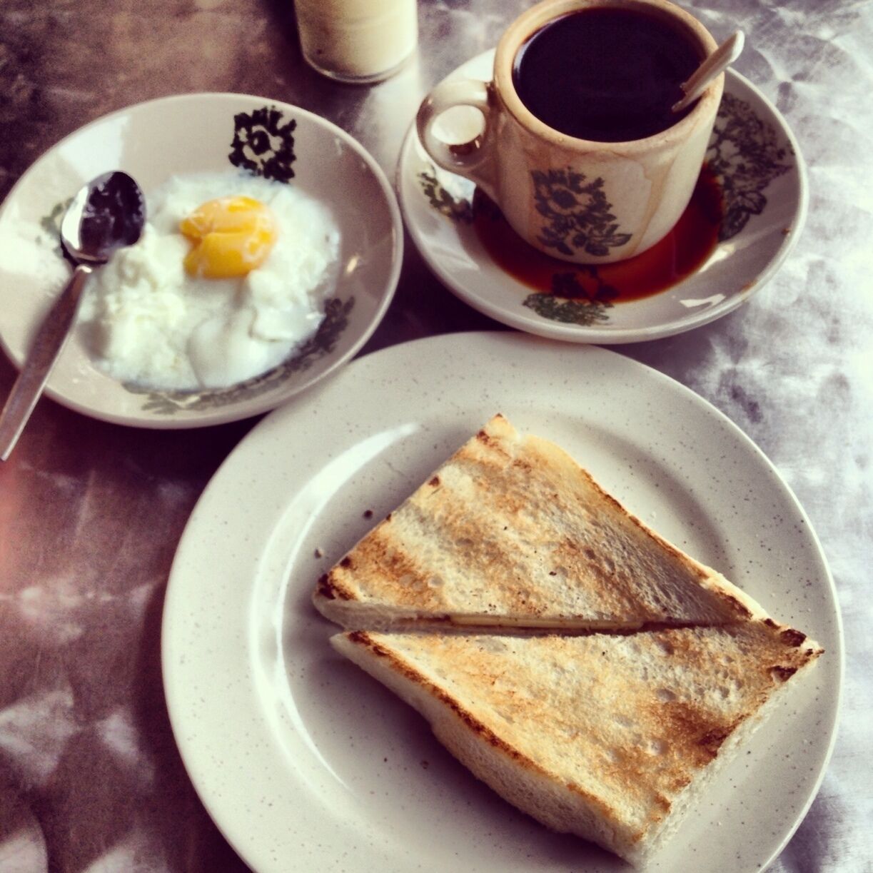 Forget the hotel breakfast and venture out to the streets. Try what the locals have for their breakfast like this typical toast set. Charcoal toasted bread with butter and kaya, half boiled egg and local coffee.