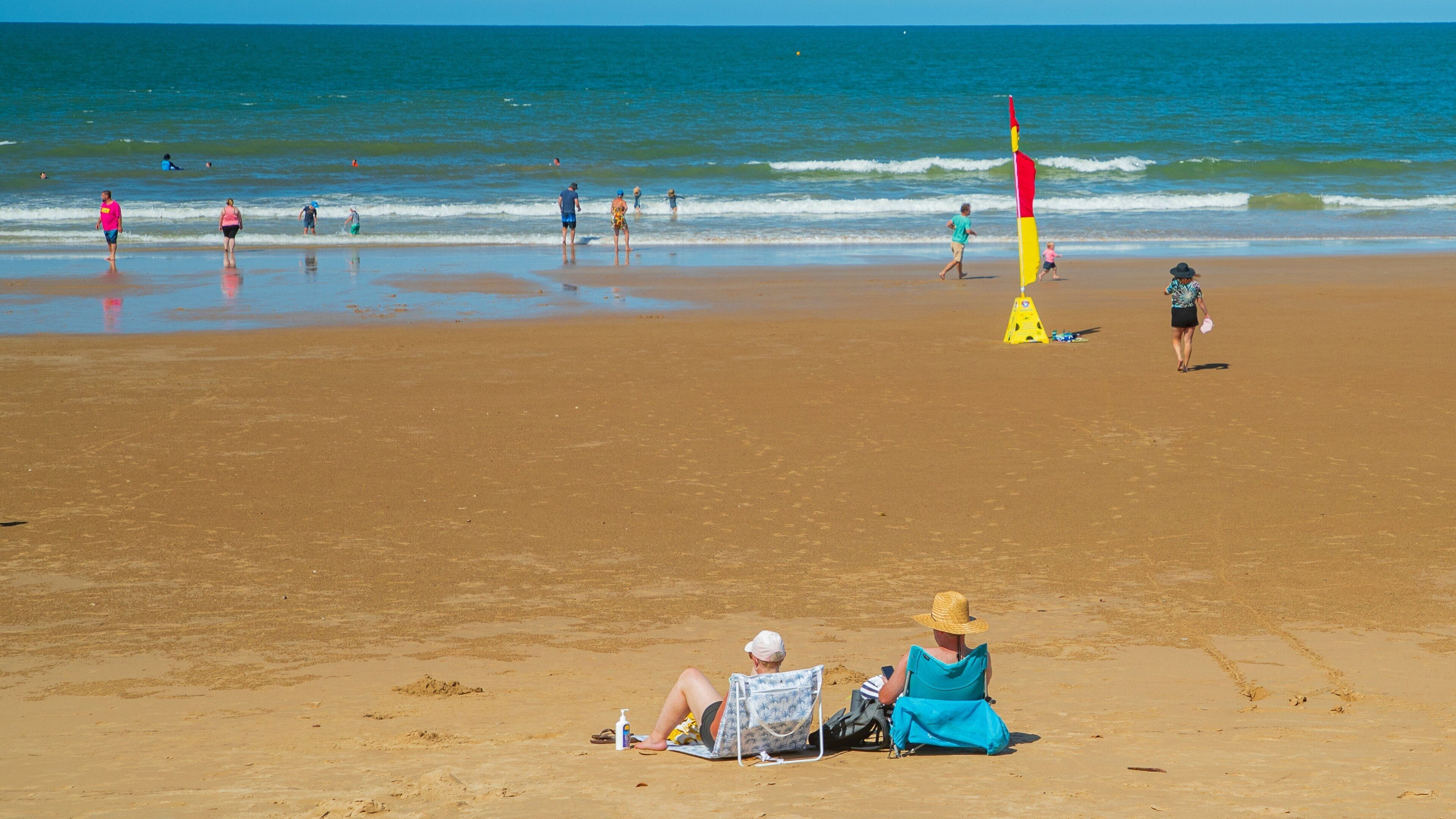 Bargara Beach showing a sandy beach and general coastal views as well as a couple