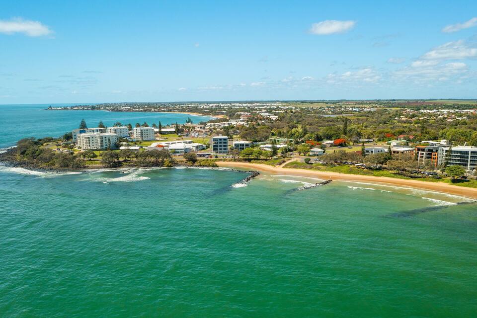 A coastal town with a beach, ocean, and residential buildings.