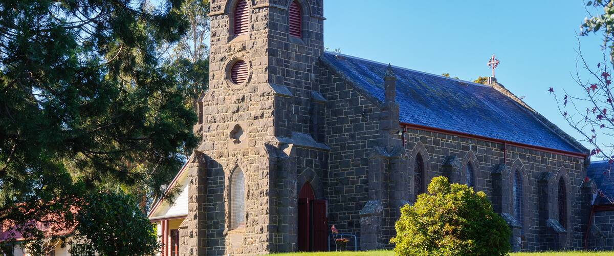 A historic stone church with a prominent tower and arched windows.