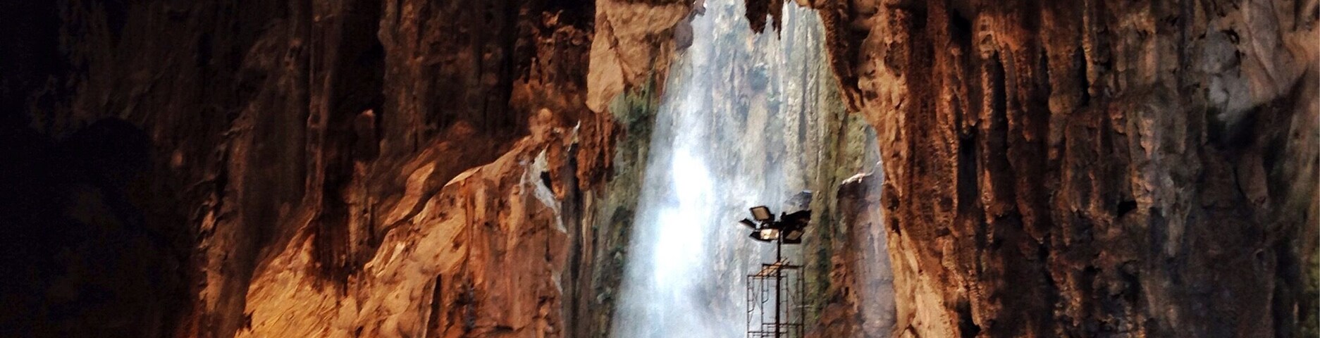 Una cueva con una abertura amplia y una escalera que conduce al interior.