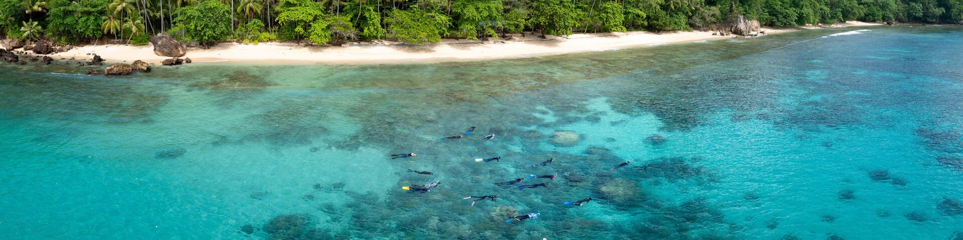 Snorkelers explore a coral reef fringing the tropical island of Bangka, just north of Sulawesi in Indonesia. This area is part of the Coral Triangle and harbors very high marine biodiversity.