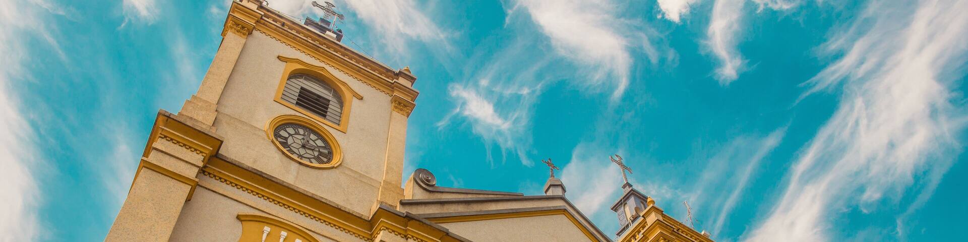 Brazilian catholic church with yellow details and blue sky with white clouds - Porto Feliz, São Paulo - Brazil