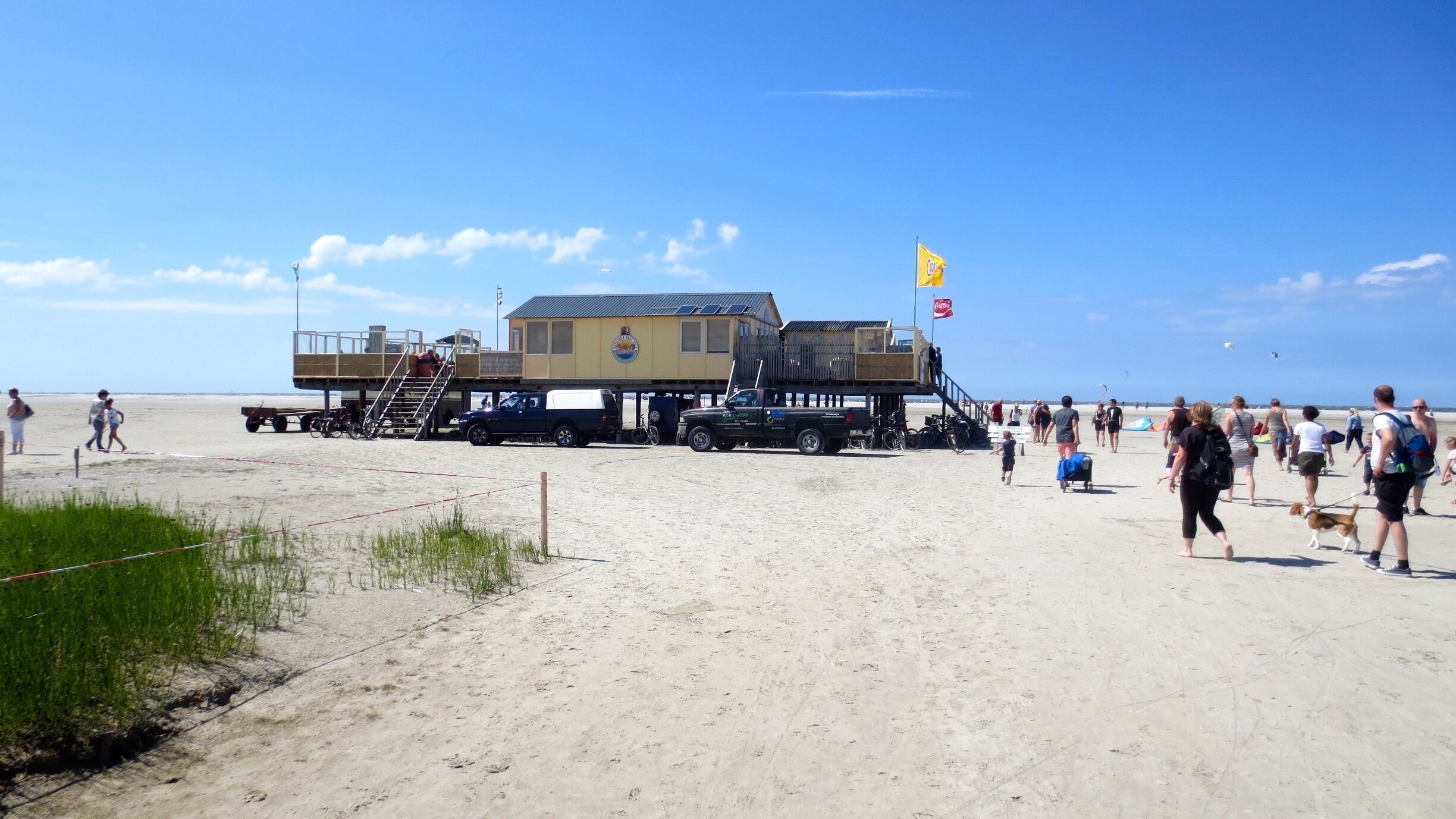A beach with a lifeguard tower, a lifeguard station, and a beachside café.