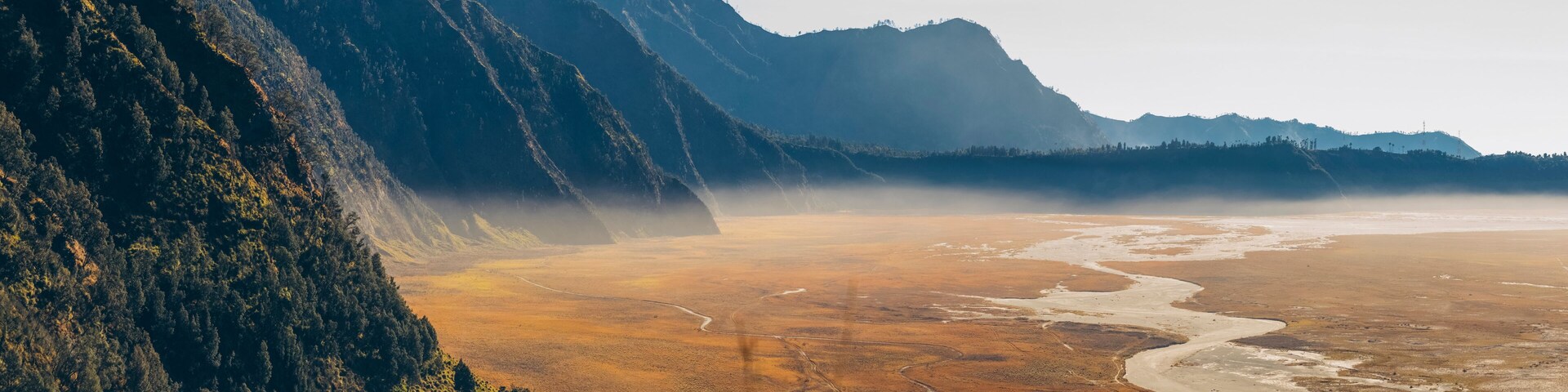 Un paisaje montañoso con un río serpenteando por un valle.
