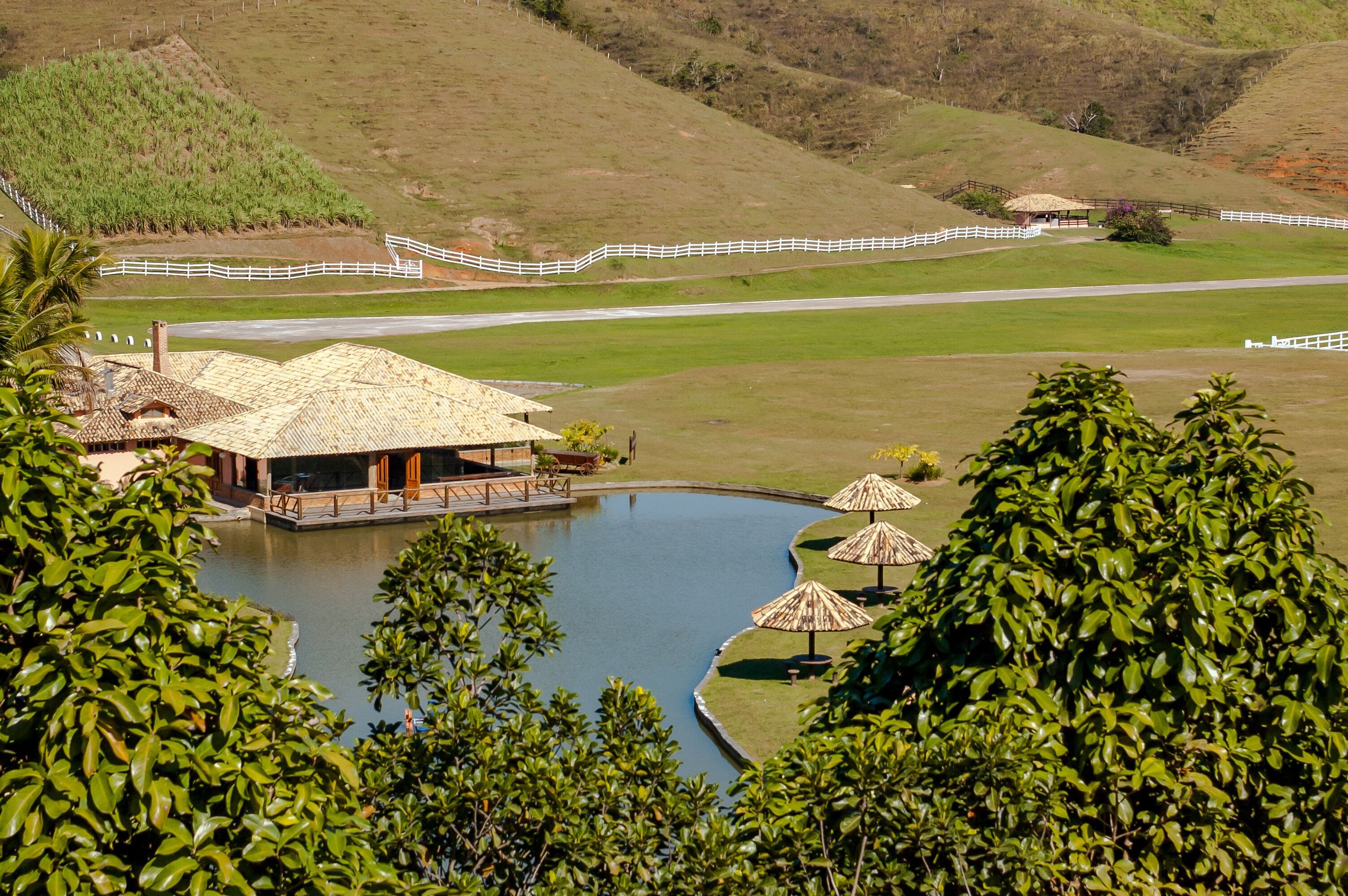 House and kiosks around a small lake, with trees and large pasture, Barra do Pirai, Rio de Janeiro, Brazil