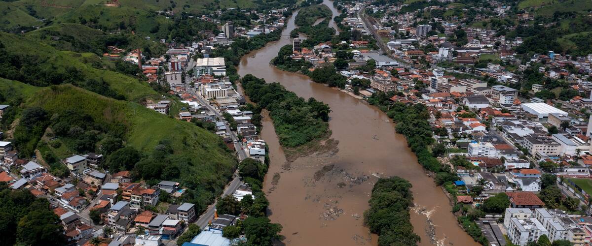 A river winding through a town surrounded by green hills.