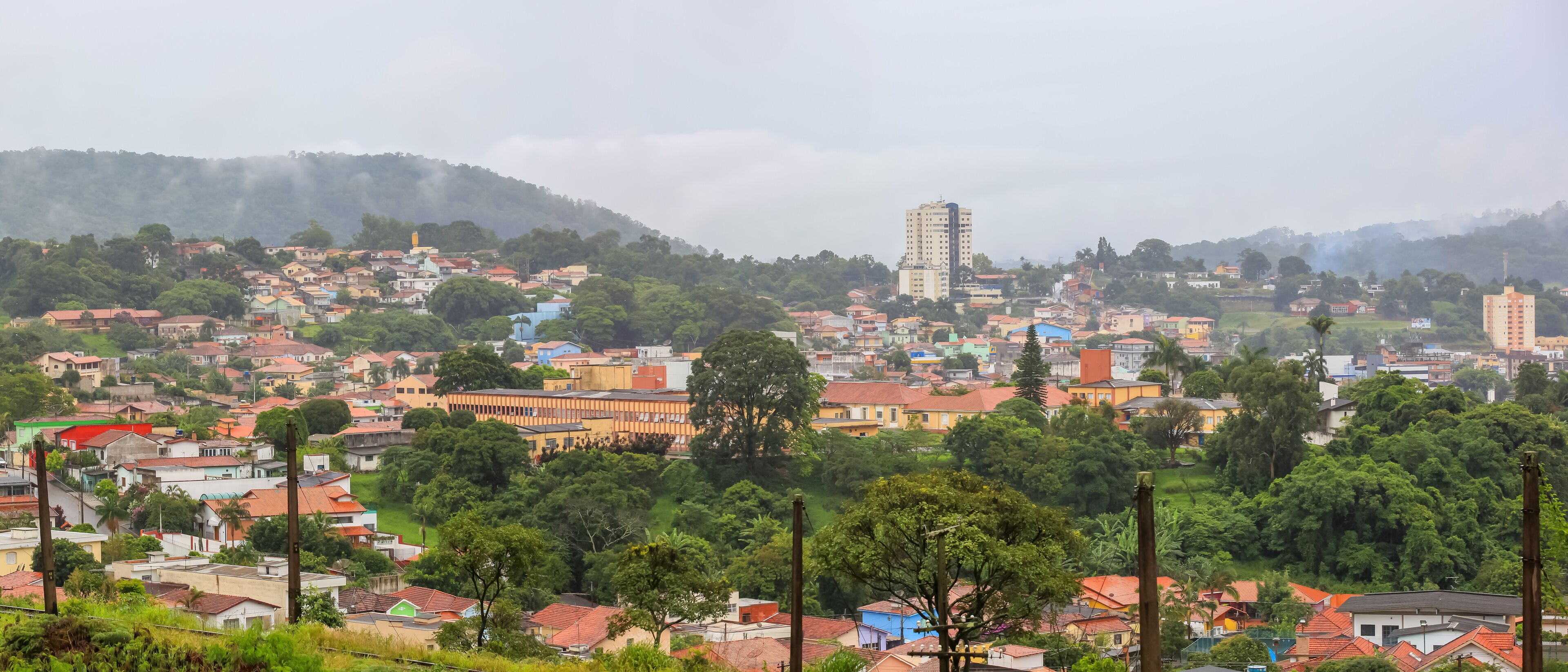 A town with colorful buildings, a prominent church, and a hill in the background.