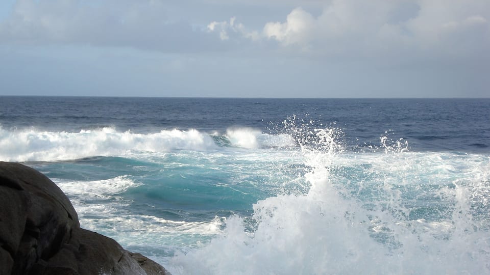A rocky coastline with waves crashing against the rocks.