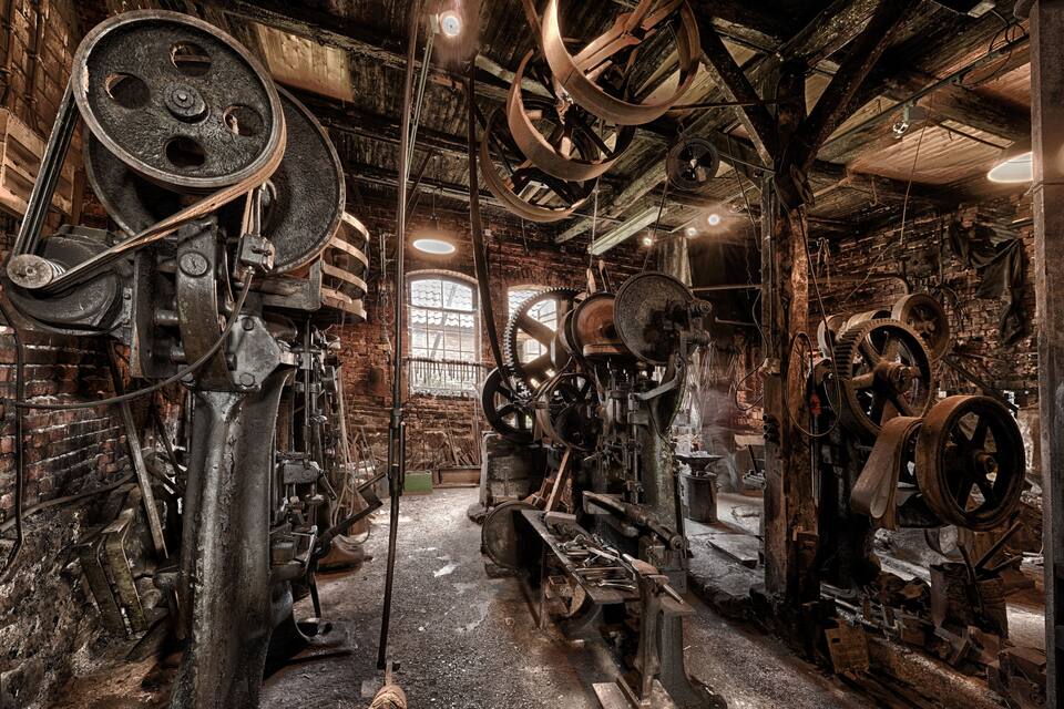 Un environnement industriel caractérisé par de grandes machines, des poutres en bois et des murs en briques.