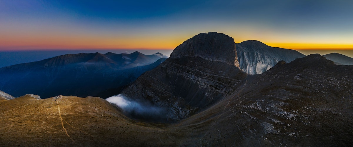 A mountain range with a prominent peak and a valley.