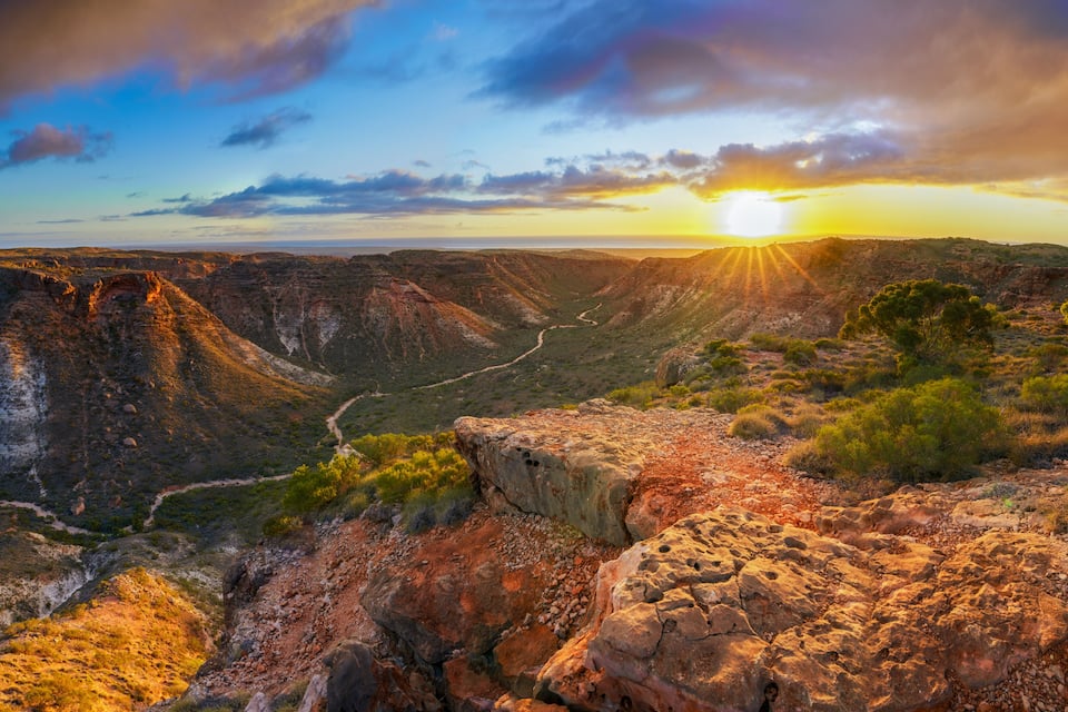 Um cânion com uma estrada sinuosa e um pôr do sol.
