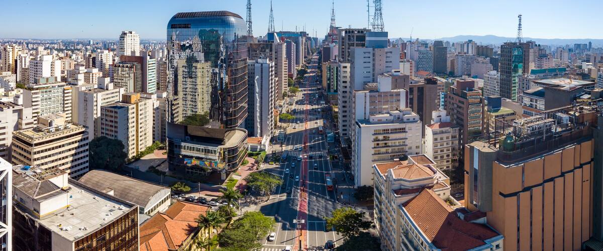 A densely packed urban cityscape with a variety of high-rise buildings, including a distinctive curved glass structure.