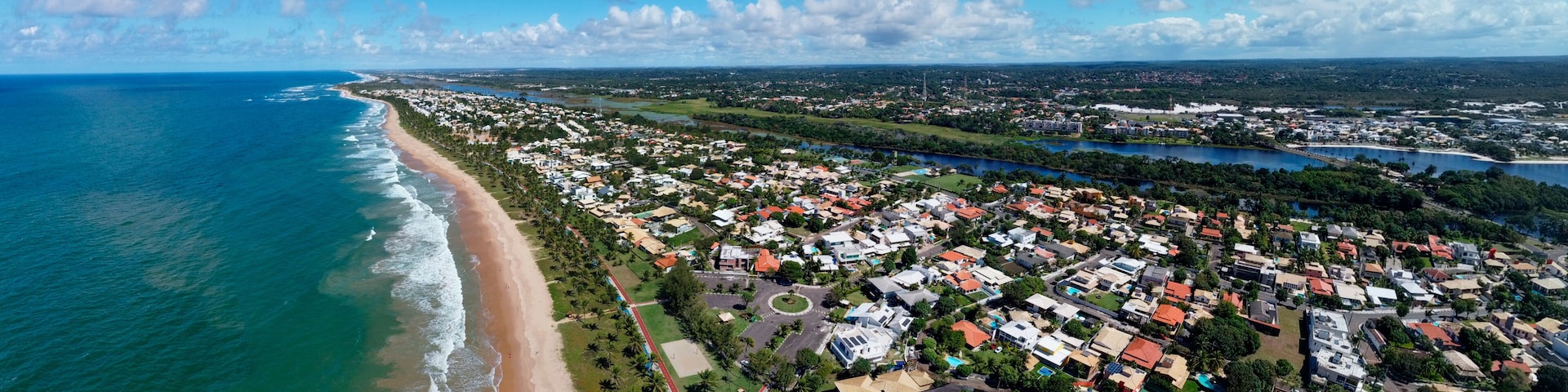 Un pueblo costero con playa, zona residencial y un río.
